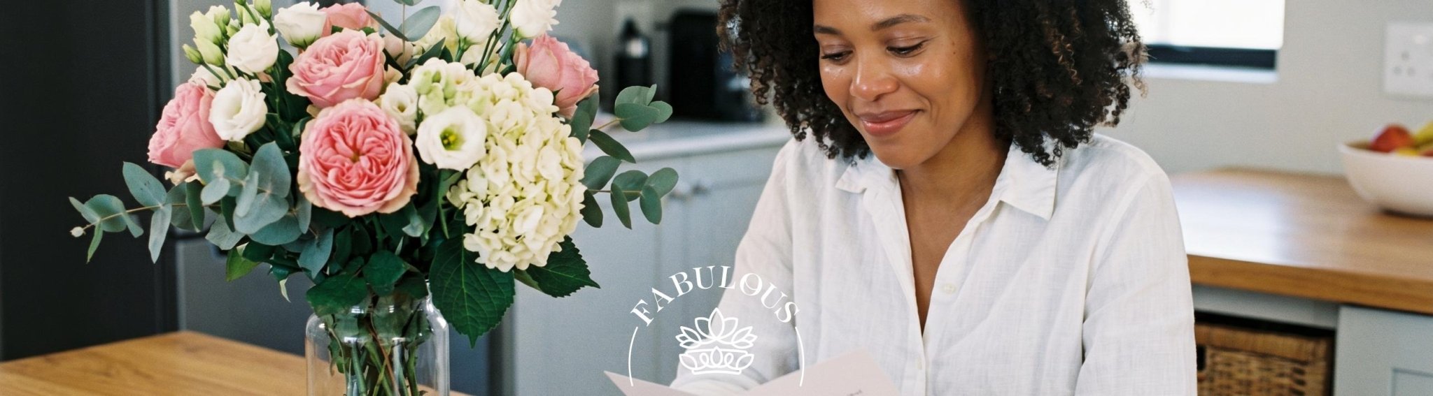 Wife smiling as she receives an anniversary bouquet of pink garden roses, white lisianthus and hydrangea from her husband