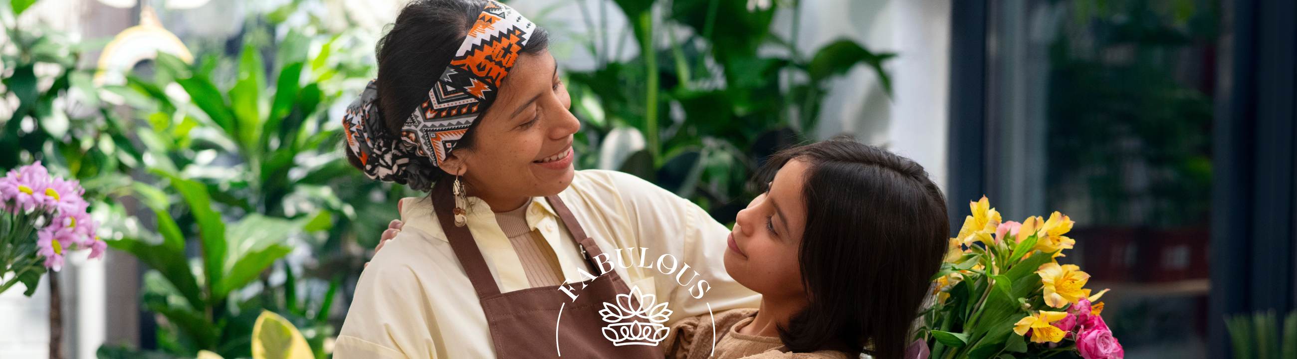 Mum and daughter smile in a leafy florist, holding a yellow-pink bouquet — header image for “Fabulous Birthday Wishes for Mom” blog.
