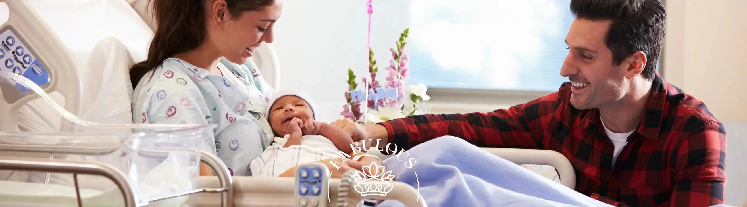 Happy new parents in a hospital room, mother holding newborn baby while father looks on smiling.