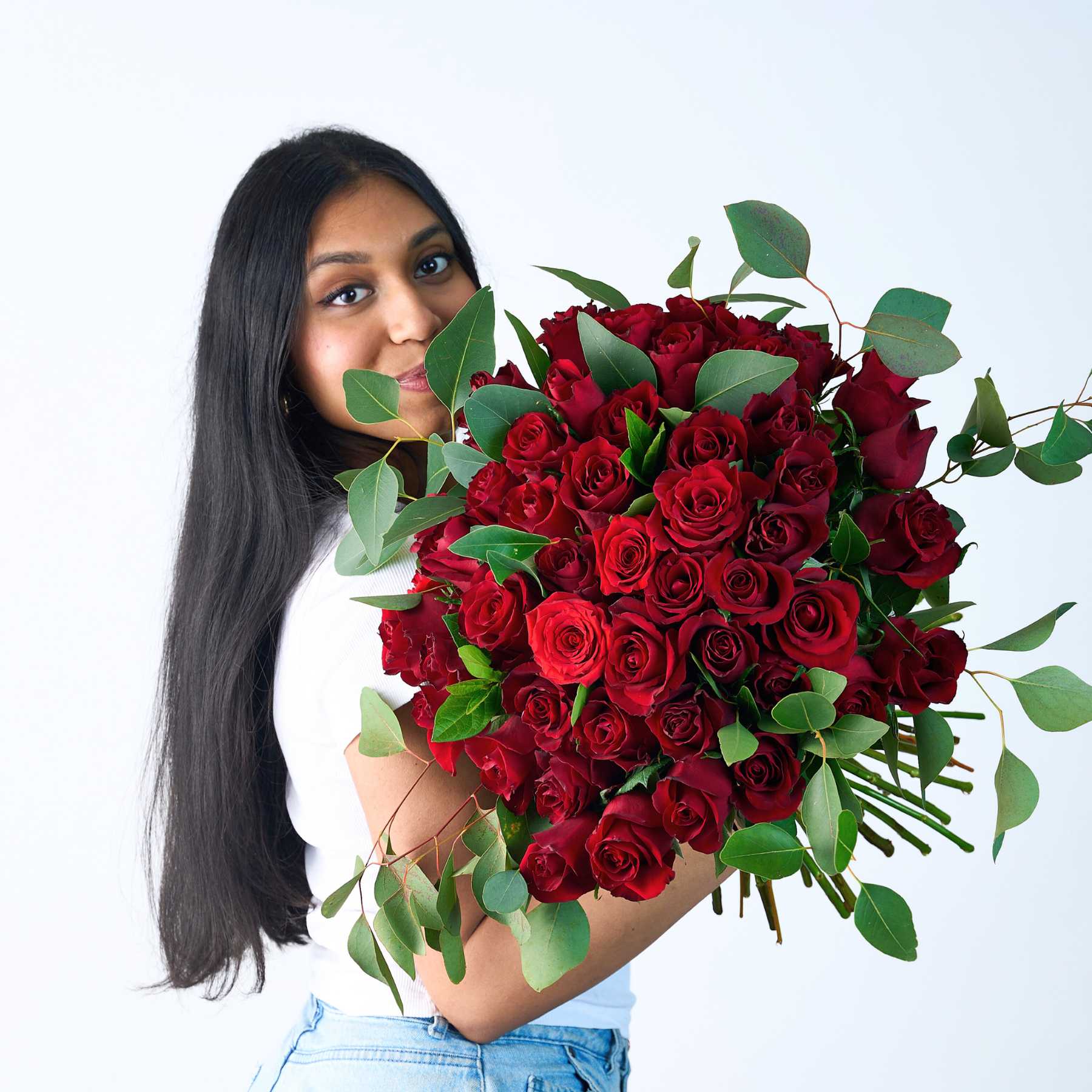 Woman holding a stunning bouquet of 50 red roses, showcasing the beauty of a 50 Red Rose Bouquet from Fabulous Flowers and Gifts