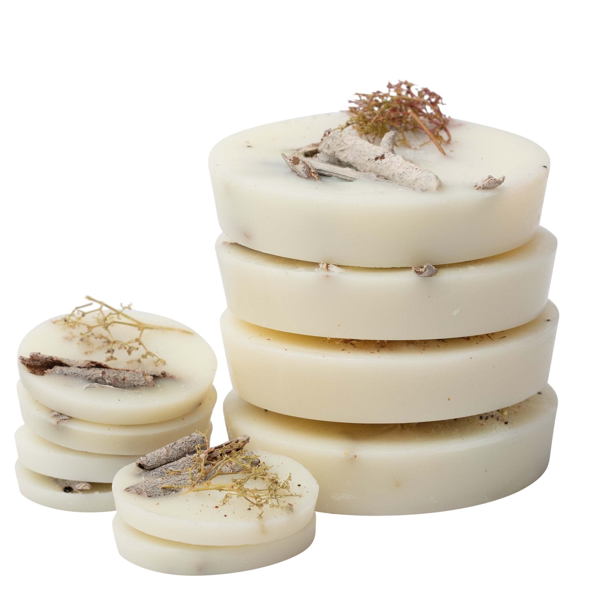 Stack of white soap bars with natural elements on a white background