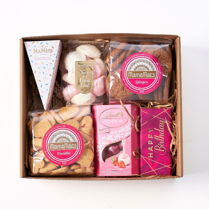 A Box Full of Lovely - An open gift box containing an assortment of sweet treats including Mamamac's vanilla and ginger cookies, Lindt Lindor strawberries and cream chocolates, and festive birthday packaging.