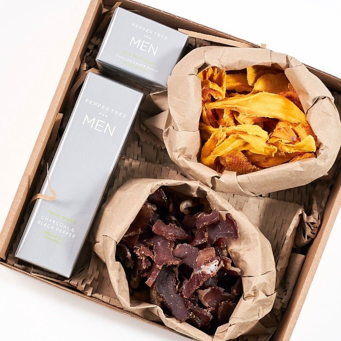 A Gentleman’s Pause - Fabulous Flowers & Gifts top-down view of luxury men’s gift box with snacks and grooming essentials.