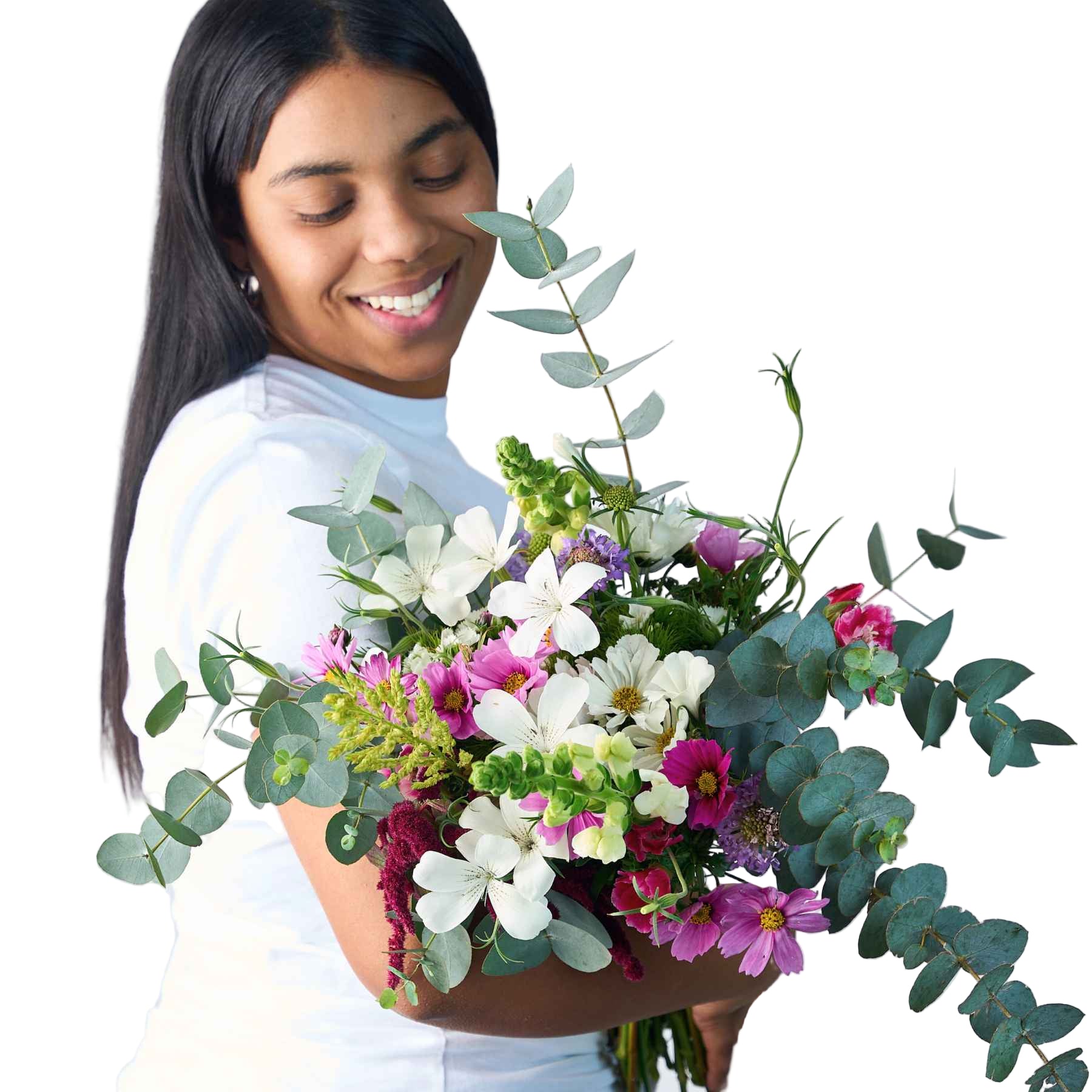 A woman smiling while holding a large bouquet of wildflowers and greenery, representing the 'A Walk in the Woods' flower bouquet.