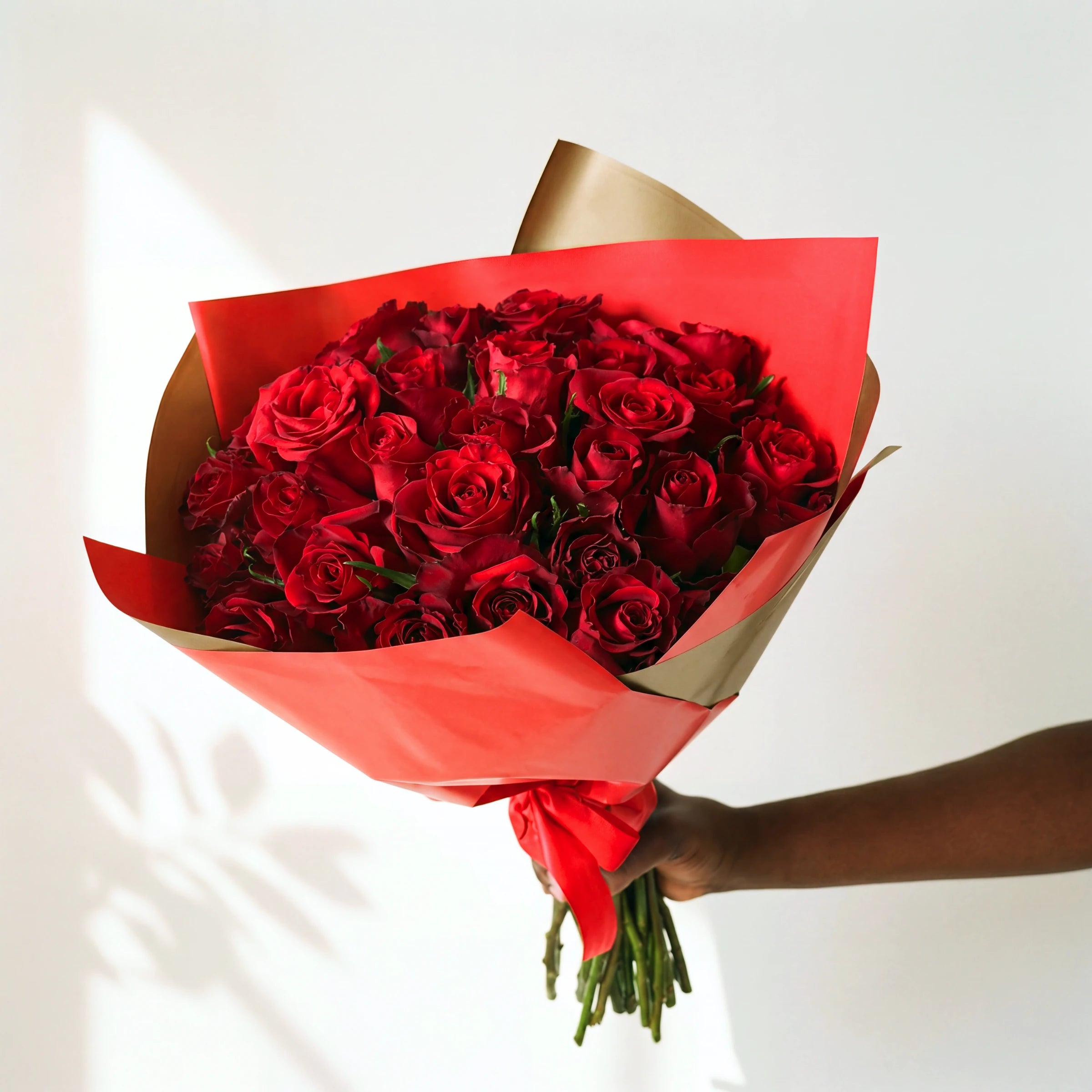 36 red roses in the largest Amour bouquet, hand-tied with a red ribbon in red and gold wrapping