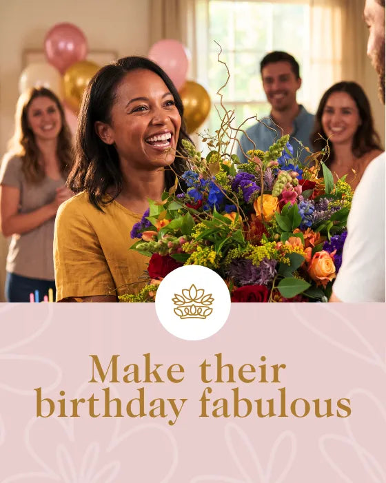 Happy woman receiving a bunch of colourful flowers for her birthday with friends and balloons in the background.