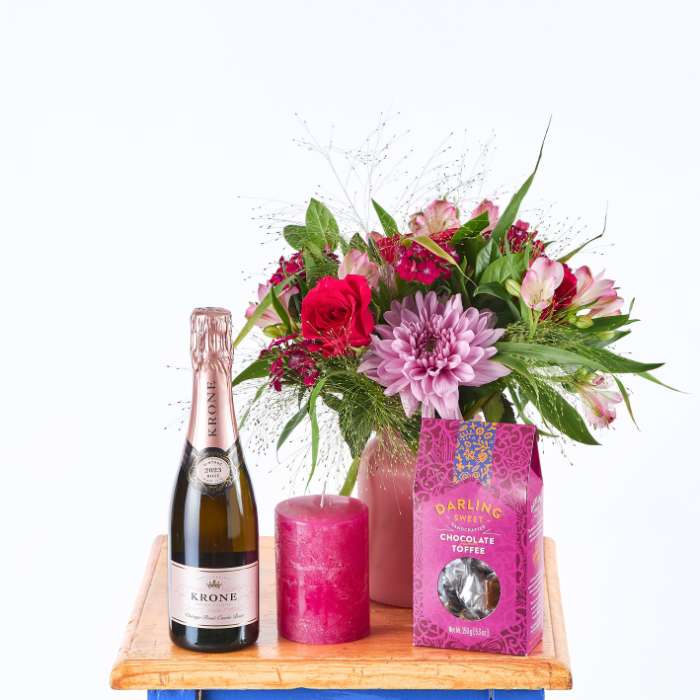Elegant Bloom and Bubble gift set with pink roses, Krone champagne, and Darling sweet chocolate toffee.
