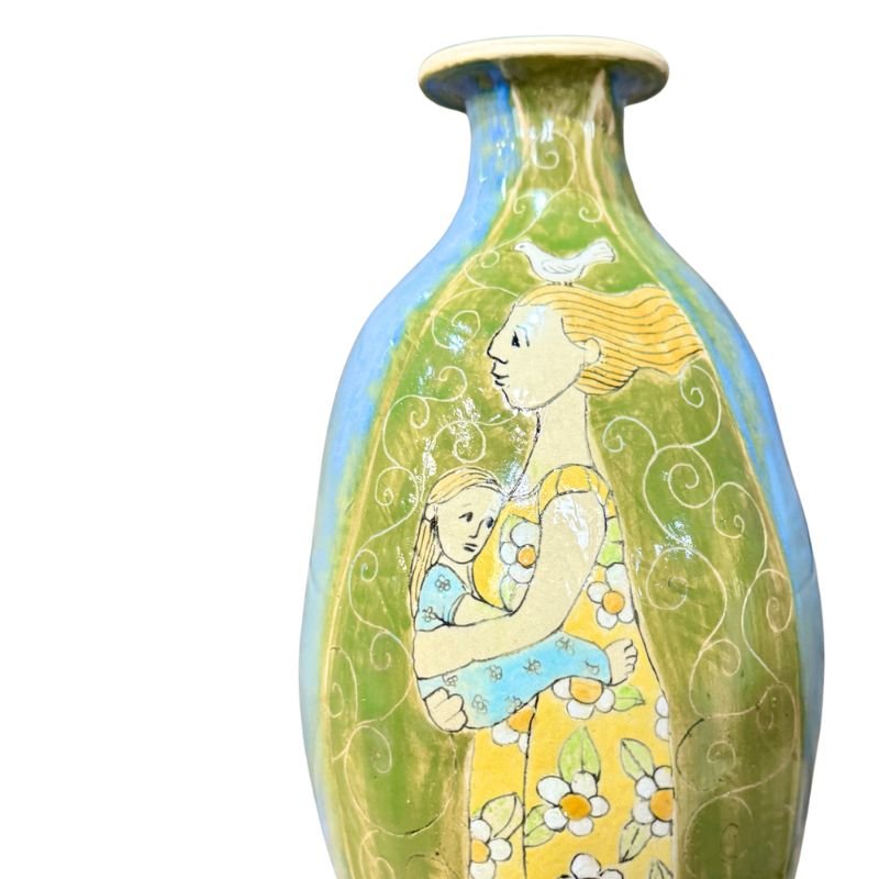 Decorative vase with artistic design of a woman holding a child on a white background