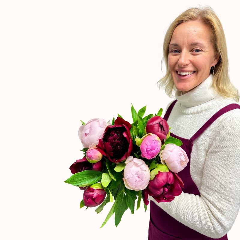 Blush & Merlot - Fabulous Flowers and Gifts bouquet held at waist height by florist wearing white and maroon
