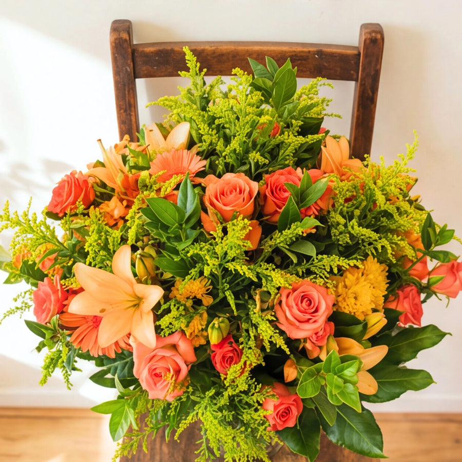 Orange roses, a peach lily and an orange gerbera in the Bright Orange Glass Vase arrangement