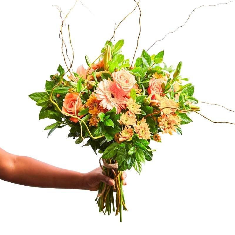 Bouquet of flowers held by a hand on a white background