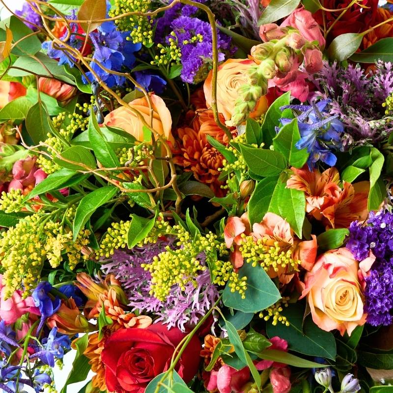 Colorful bouquet of flowers with a variety of colors including red, purple, yellow, and green.