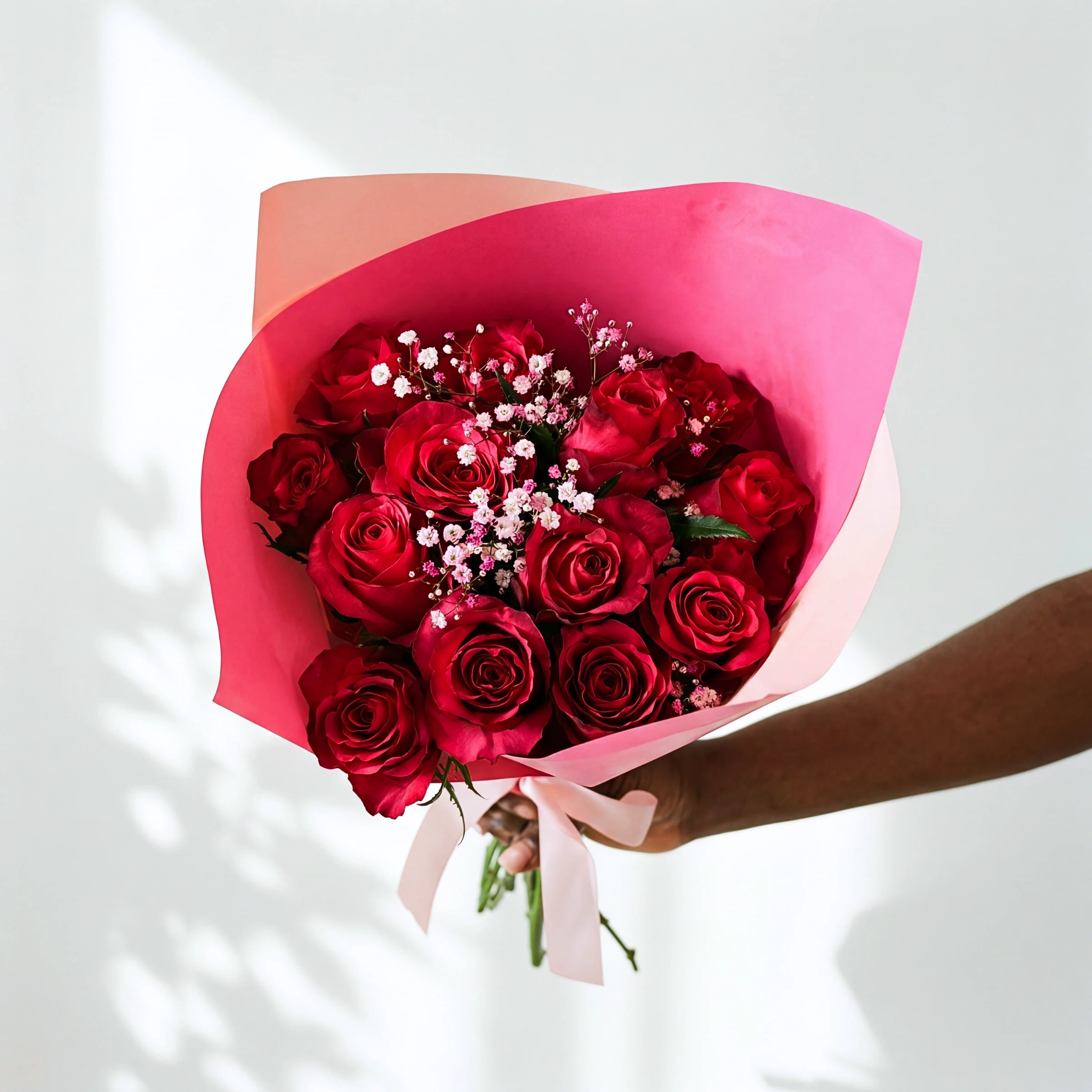Cerise Crush bouquet of red roses with pink and white gypsophila, wrapped in cerise paper with a pink ribbon