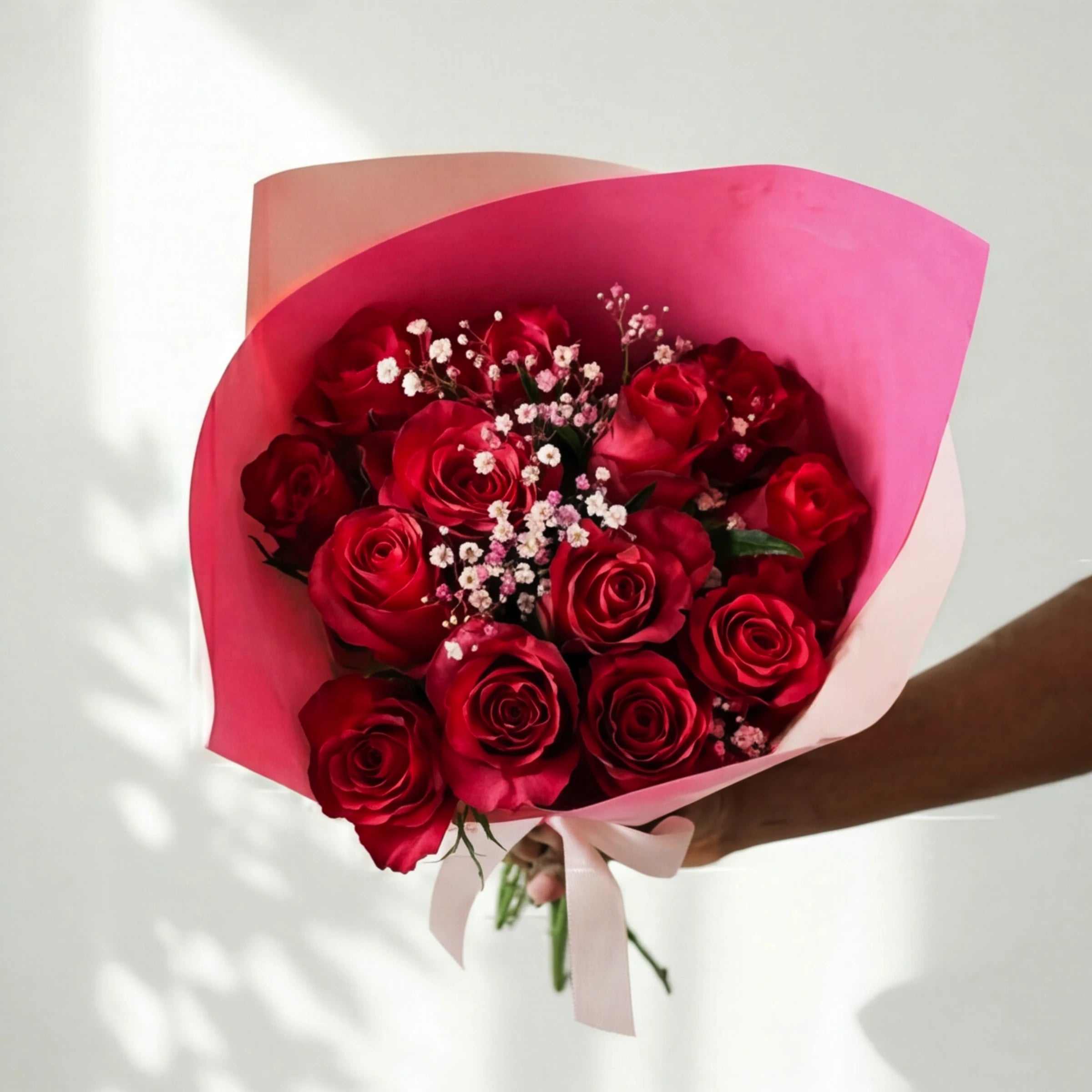 Top-down view of the Cerise Crush red roses with pink gypsophila in cerise wrap