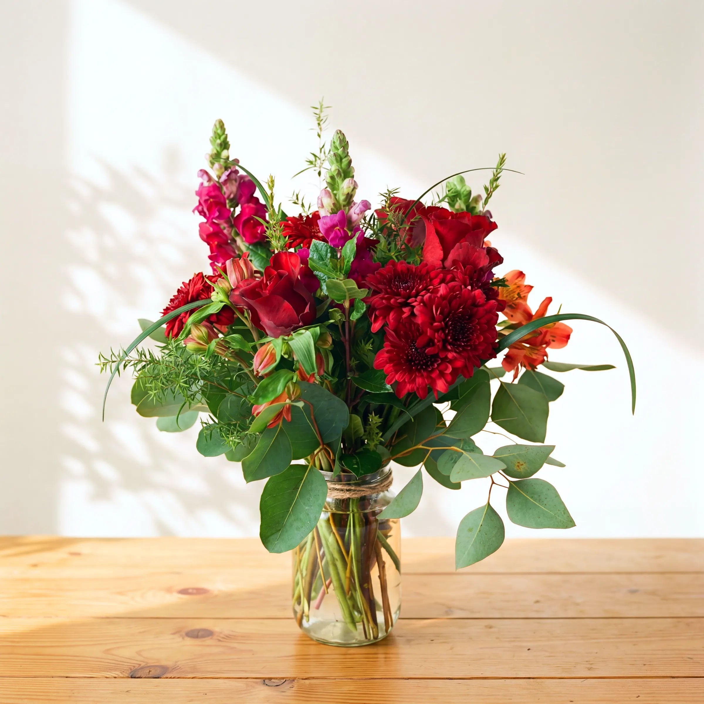 Charming flower arrangement in a glass jar with red roses, chrysanthemums, gerbera and orange alstroemeria, Fabulous Flowers