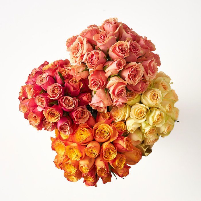 Top view of Cherry Elegance floral arrangement, a heart-shaped design with gradient shades from yellow to deep pink roses.