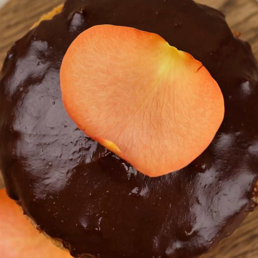 Close-up of dark chocolate ganache with orange rose petal on GF chocolate orange cake by Fabulous Flowers