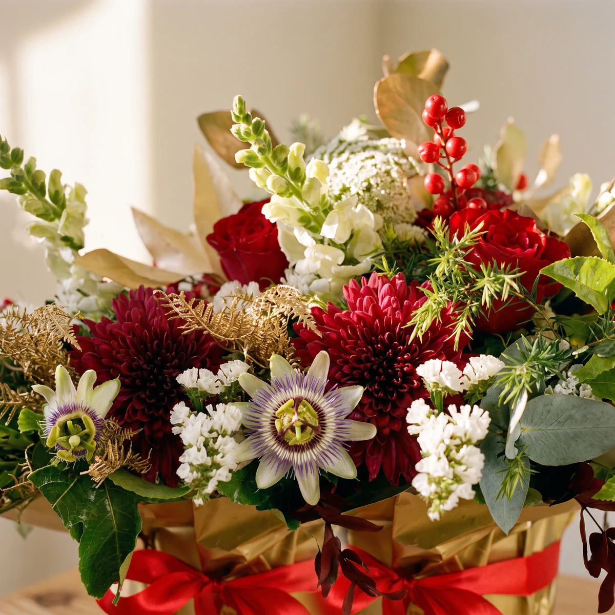 Close-up of red roses, burgundy chrysanthemums, white statice, red berries and gold leaves, Fabulous Flowers South Africa