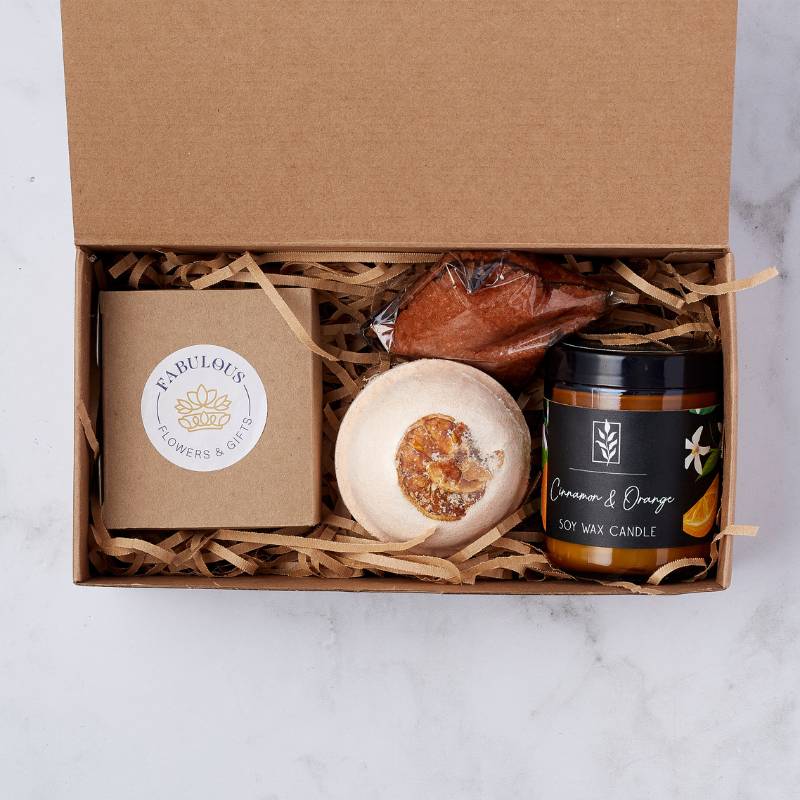 Indulge in the warmth of the Cinnamon & Orange Gift Box featuring a fragrant candle, bath bomb, and sweet treat for relaxation.