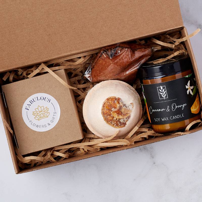 Enjoy the cosy essence of the Cinnamon & Orange Gift Box with a soy wax candle, a bath bomb, and a delightful chocolate treat.