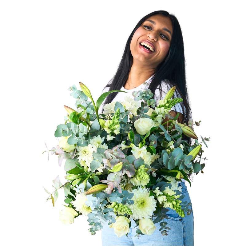 Classic White Bouquet in lush white blooms and eucalyptus, model laughing while holding arrangement on white background
