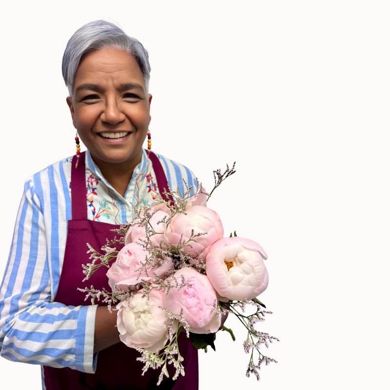 Florist holding Clouds of Love bouquet of pale pink peonies and soft foliage by Fabulous Flowers and Gifts.