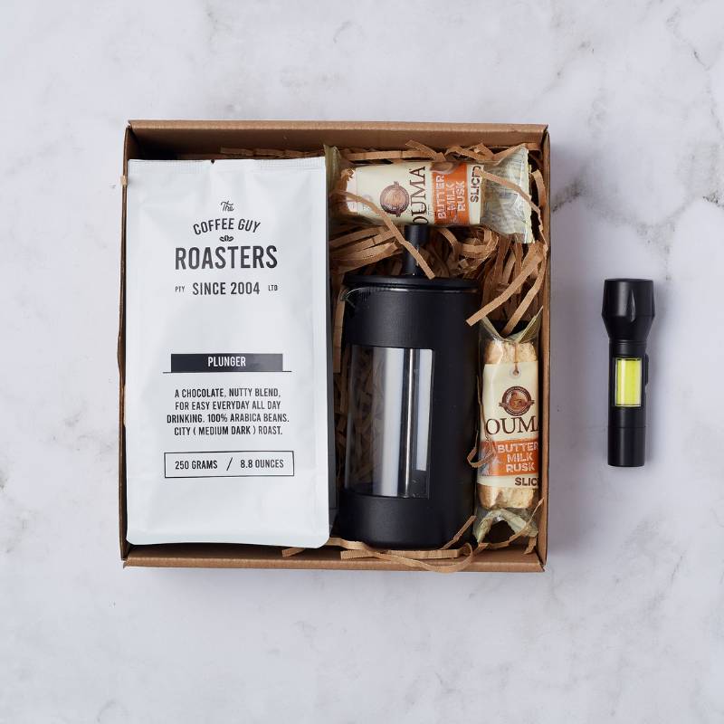 Top view of Coffee Lover's Escape Gift Box featuring coffee plunger, roasted coffee beans, and buttermilk rusks.