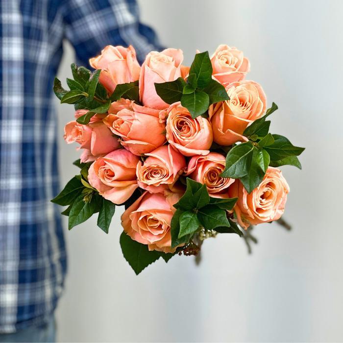 Coral Charm Rose Bouquet – hand-held bunch of coral roses with deep green foliage, perfect for gifting by Fabulous Flowers & Gifts