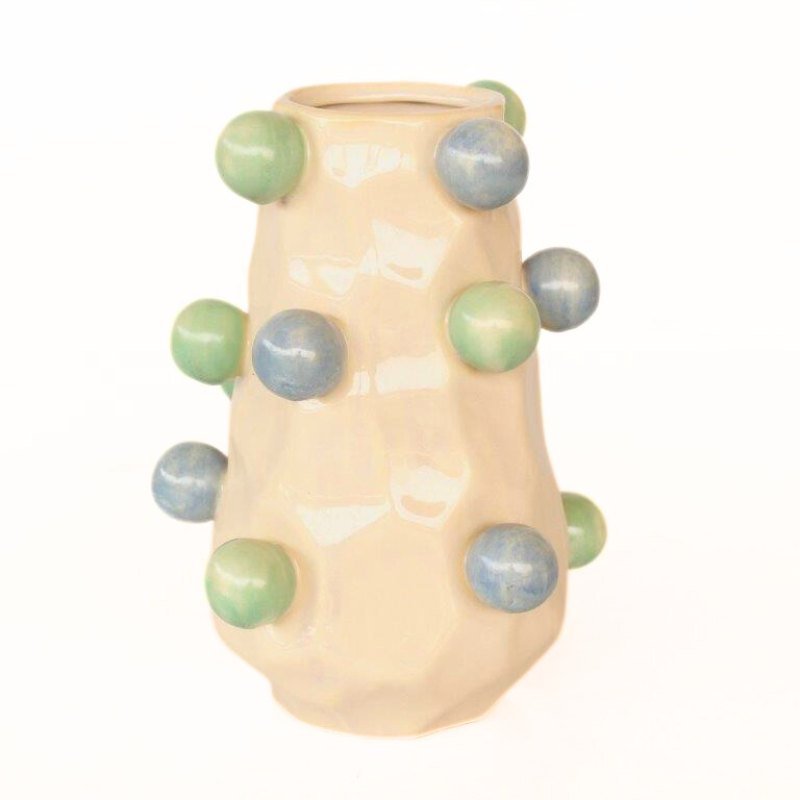 Beige ceramic vase with green and blue spherical decorations on a white background