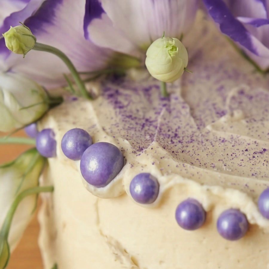 Macro of purple edible pearls and dusted buttercream finish on Creamy Violet Dream Cake by Fabulous Flowers