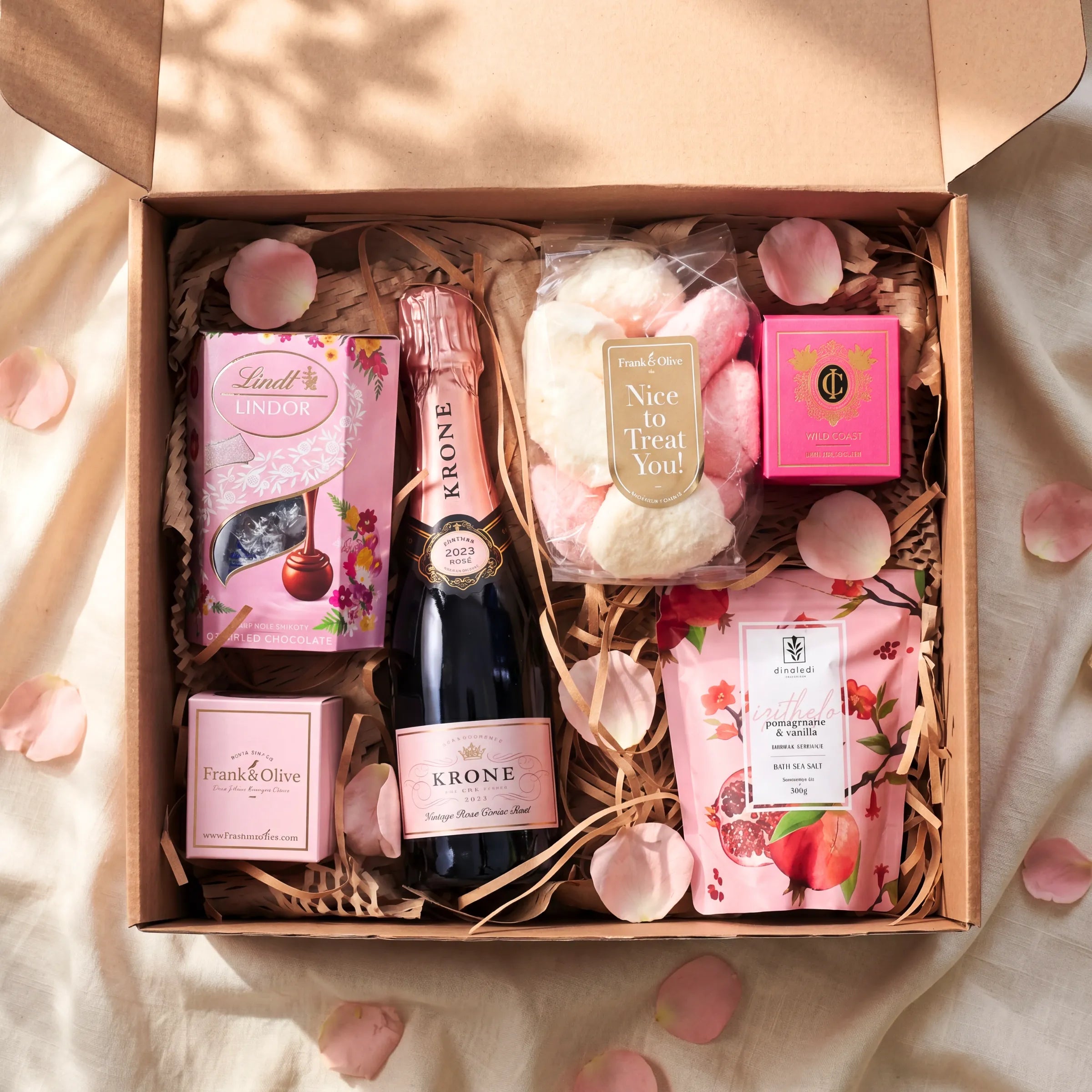 Top view of Daydream Delight Gift Box with Krone Vintage Rose 2023, Lindt Lindor, Frank and Olive marshmallows, Cape Island Wild Coast and Dinaledi pomegranate vanilla bath salt 300g