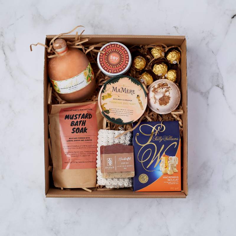 Deluxe Pamper Gift Box featuring mustard bath soak, Turkish delight, macadamia nougat, bath salts, handmade soap, and Ferrero Rocher chocolates.