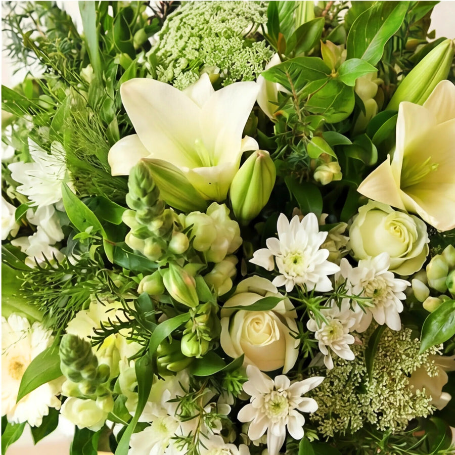 Close-up of white lilies, cream roses, chrysanthemums and Queen Anne's lace in the Elegant White Bouquet since 1999