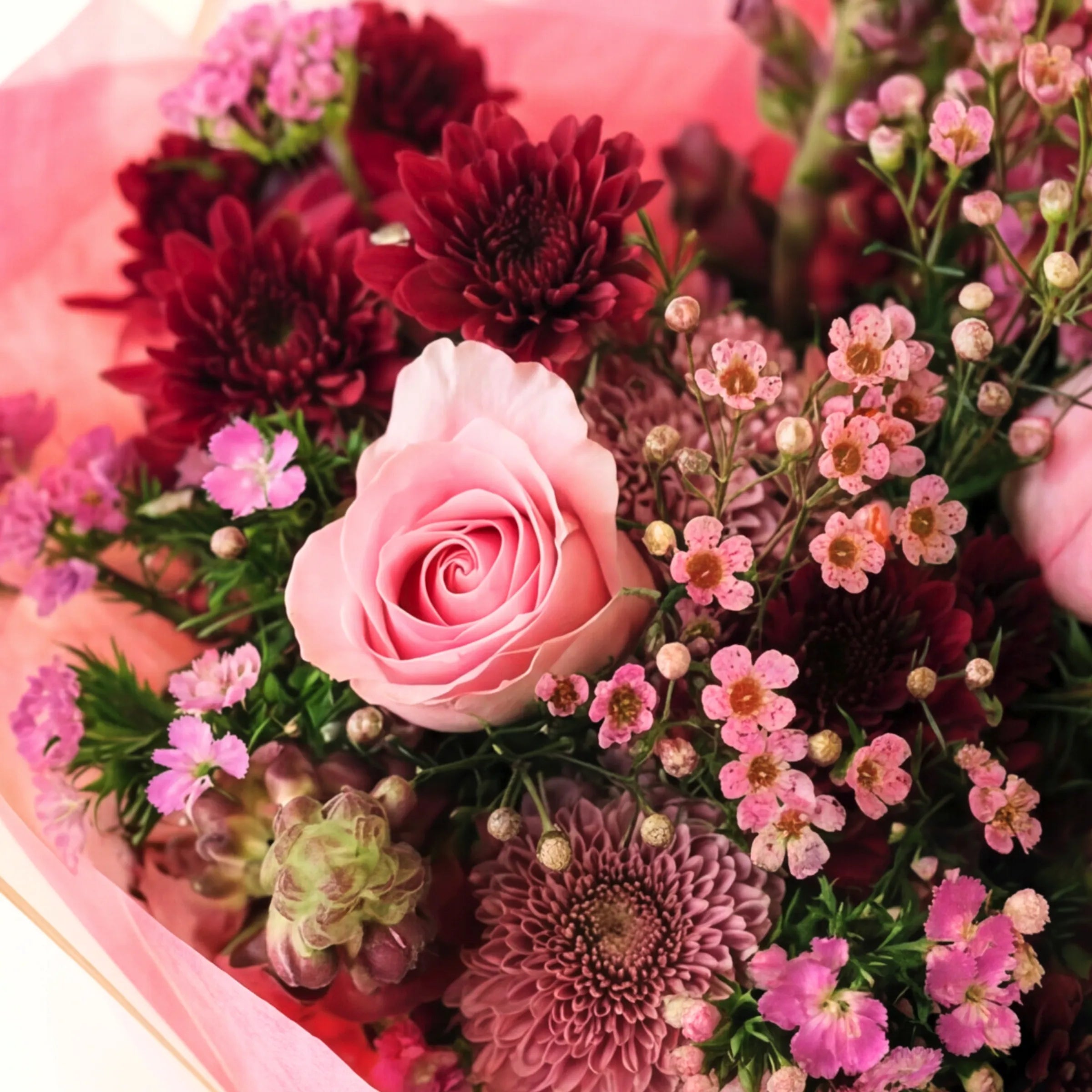 Close-up of the Enchanted Garden bouquet, soft pink rose, wine chrysanthemums and pink waxflower, hand-tied since 1999