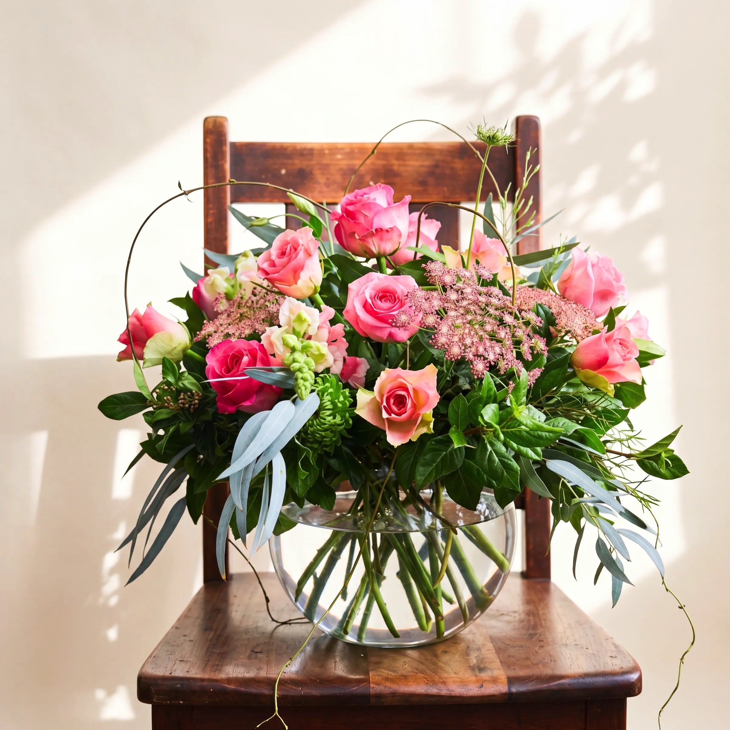 Fabulous Rose Bowl statement arrangement on antique chair with leaf shadow by Fabulous Flowers Cape Town