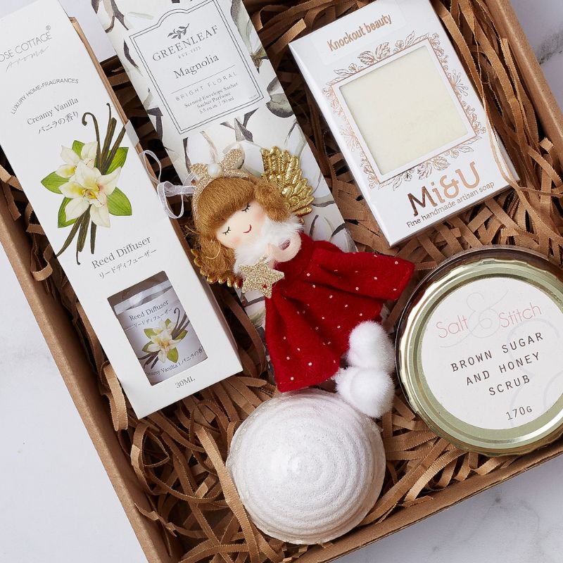 Festive Bliss Spa Gift Box with vanilla reed diffuser, handmade soap, brown sugar and honey scrub, and a festive angel figurine.
