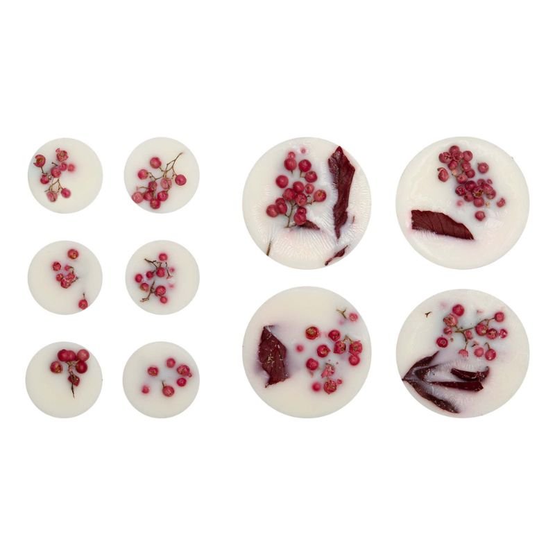 Assorted white chocolate buttons with red berry and marbled designs on a white background