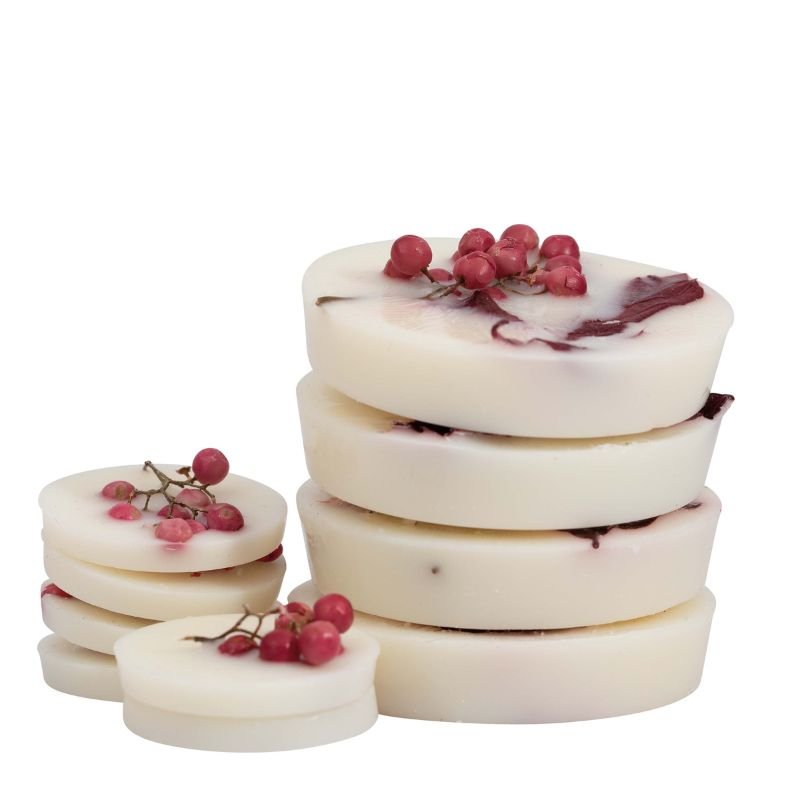 Stack of white marbled soap bars with red berries on a white background