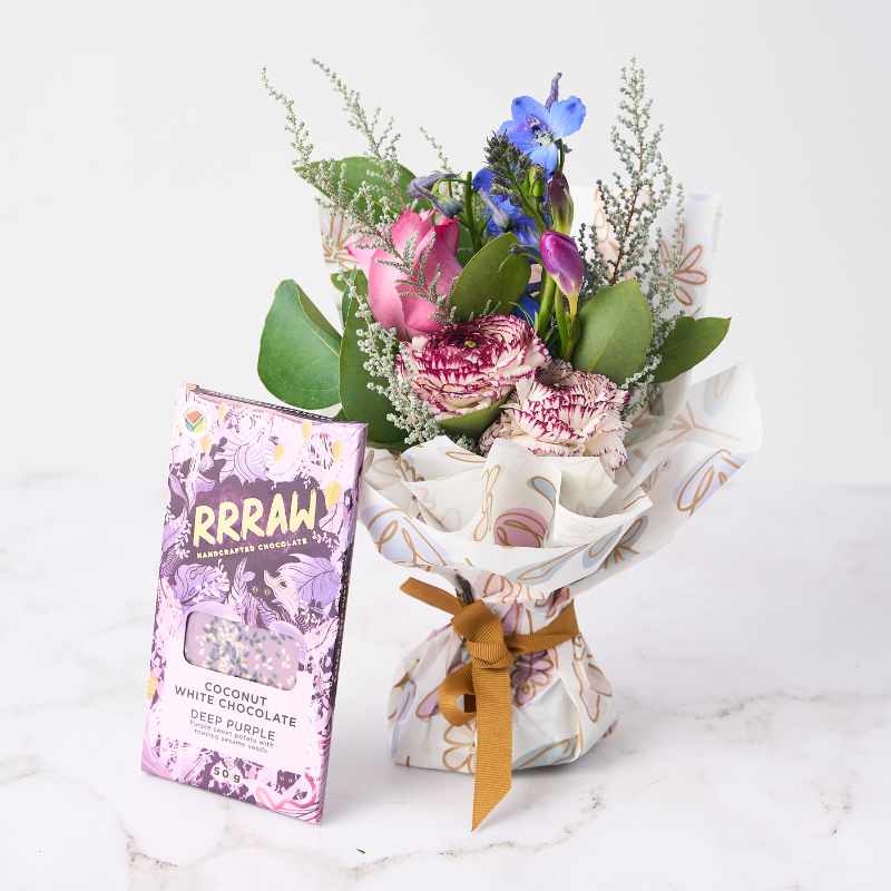 Floral Fantasy Posy - A charming posy of pink and purple flowers wrapped in floral paper, paired with a Rrraw handcrafted coconut white chocolate bar in the 'Deep Purple' flavour.