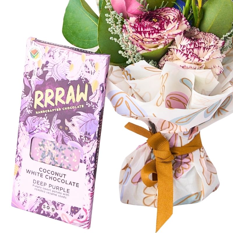 Close-up Floral Fantasy Posy and vegan chocolate — patterned wrap with gold ribbon, pink blooms and purple accents