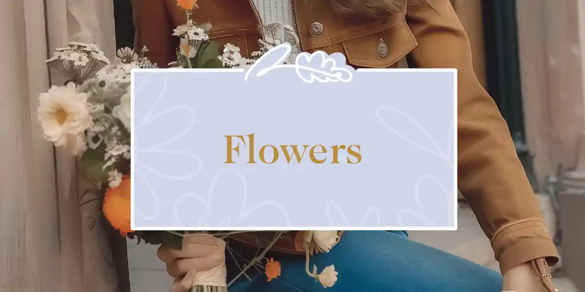 A stylish woman seated outdoors, holding a bouquet of yellow and white flowers, embodying elegance and simplicity. Fabulous Flowers and Gifts - Flowers