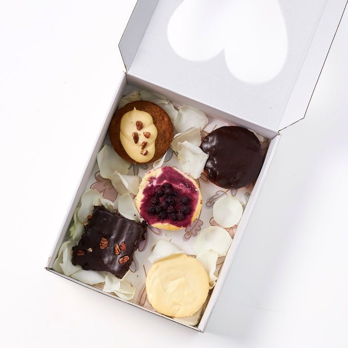 From Me, With Butter - Fabulous Flowers & Gifts top-down view of five gourmet treats in a gift box with flower petals.
