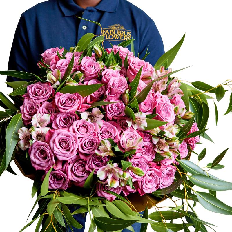 Bouquet of pink roses held by a person wearing a 'Fabulous Flowers' shirt.