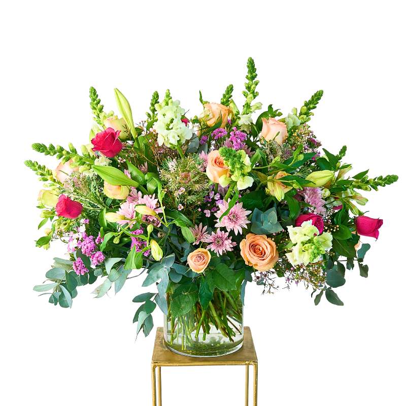 Grand and Colourful Flower Arrangement in a glass vase with pink roses, lilies, pastel blooms and lush greenery