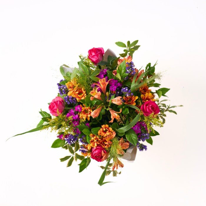 Top view of the Grateful for You bouquet, showcasing an array of pink roses, orange alstroemeria, and purple statice beautifully arranged.