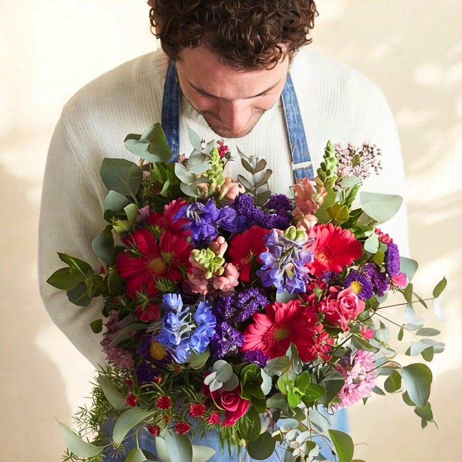 Cape Town florist smelling the jewel-tone Gratitude thank you bouquet, hand-tied at our Claremont studio since 1999