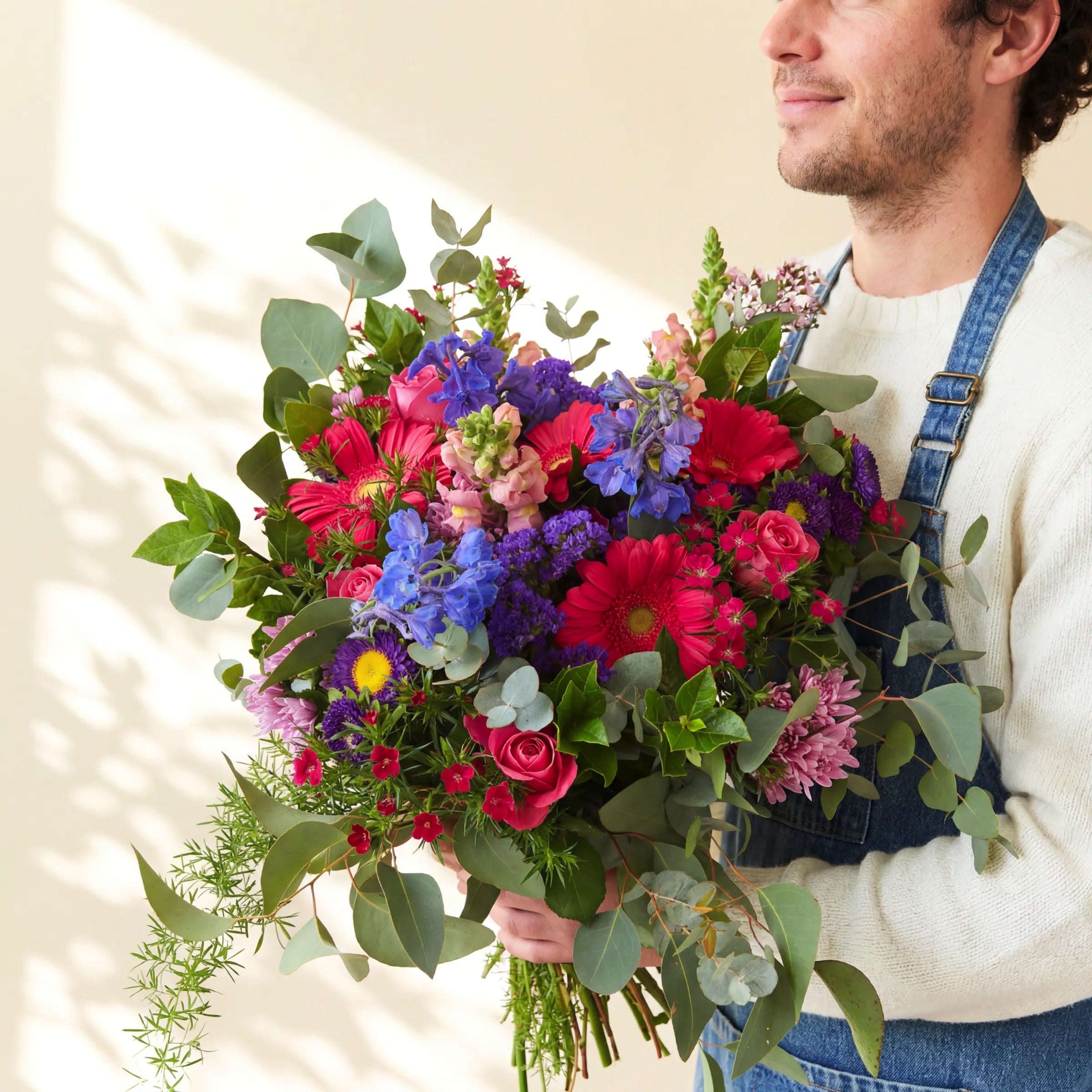 Gratitude thank you bouquet of pink gerberas, roses and blue delphinium held by a Fabulous Flowers florist, Cape Town