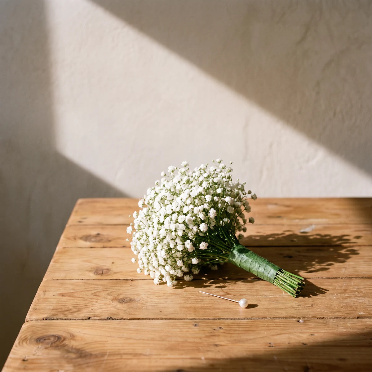 Baby's breath boutonniere with a taped green stem on a pine table, Fabulous Flowers South Africa