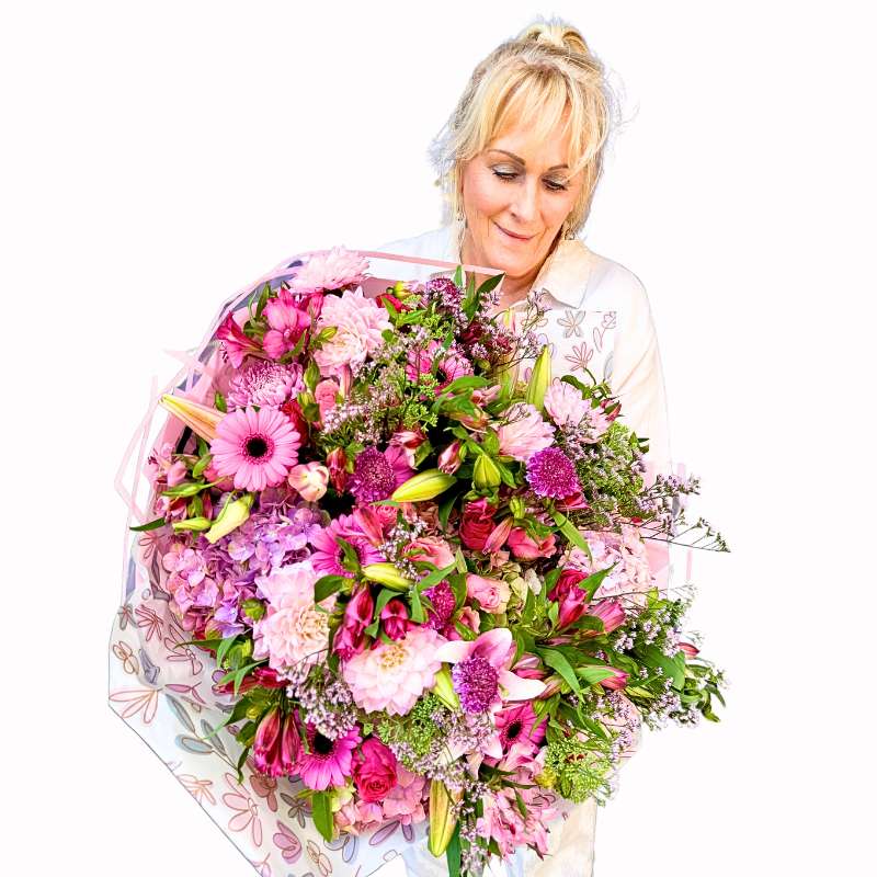 Handle with Love Bouquet close-up showing pink gerberas, blush roses, white lilies and lush greenery in gift wrap