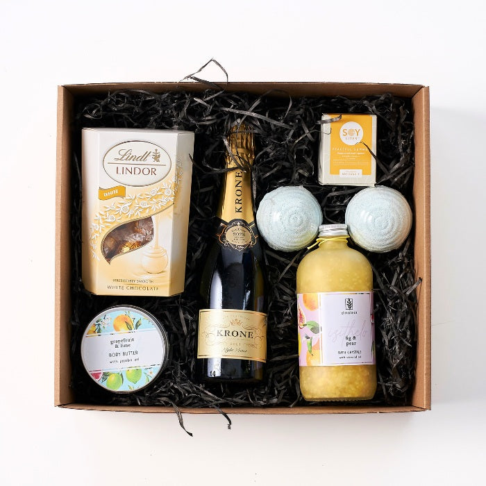 Heavenly Harmony Hamper with Krone bubbly, Lindt chocolate, bath crystals, candle, body butter, and bath bombs.